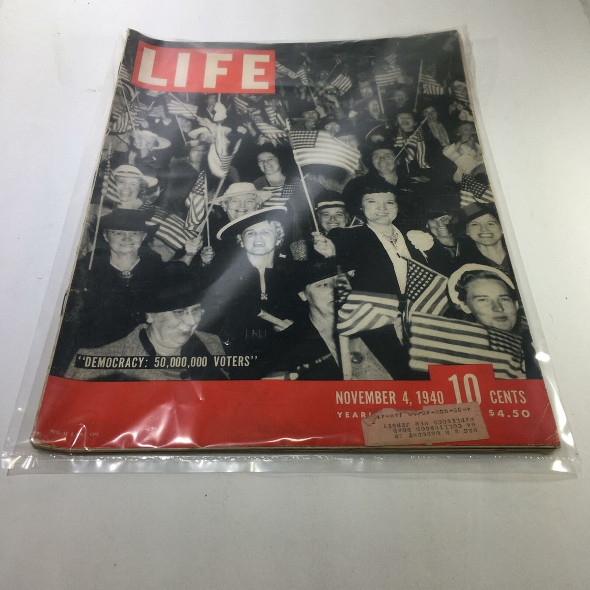 Vintage Life Magazine cover from November 4, 1940, featuring the title 'Democracy: 500,000 Voters', showcasing a gathering of people holding American flags, encapsulating a significant moment in American electoral history.