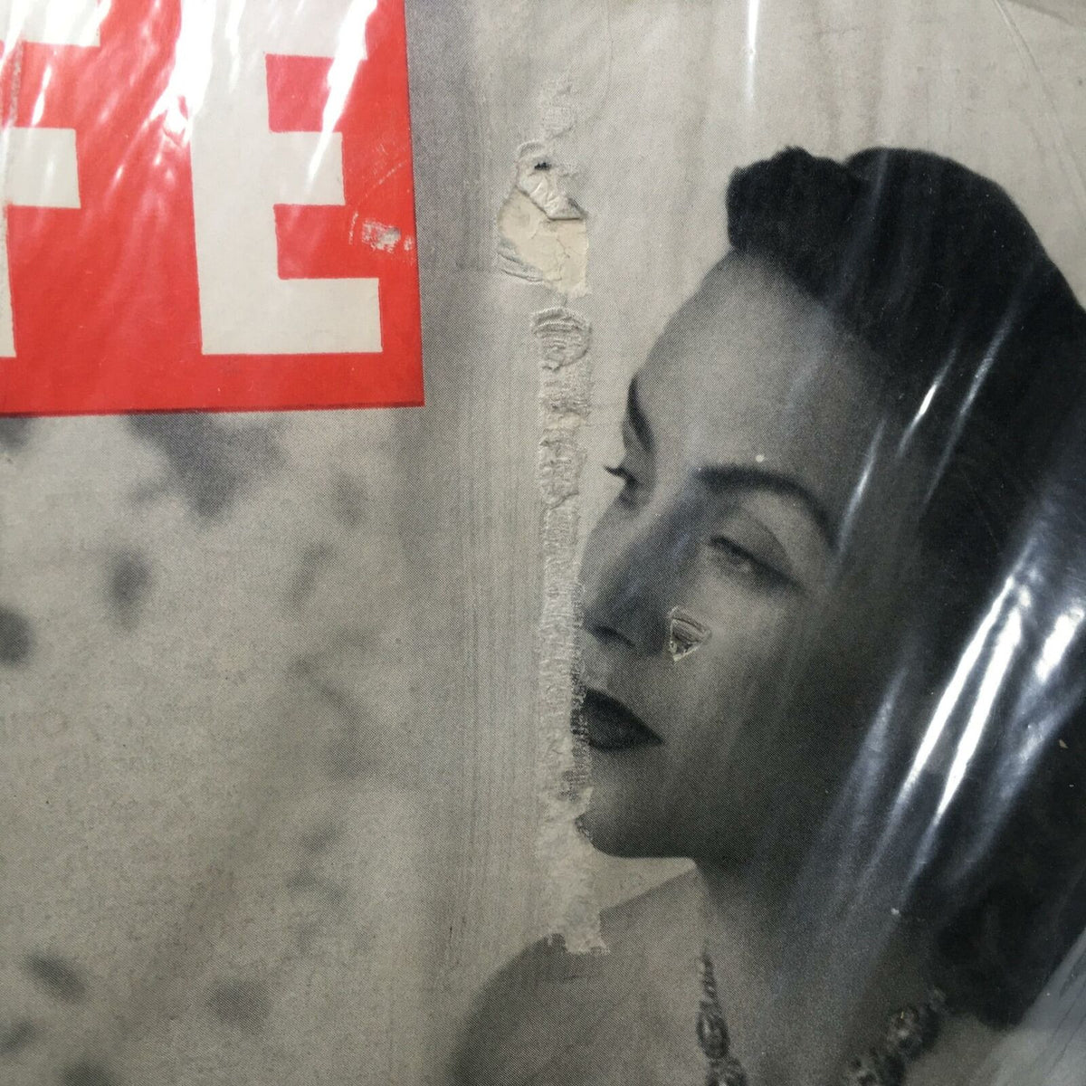 Close-up of the damaged cover of Life Magazine from May 17, 1948, showing text and a portrait of a woman, illustrating the wear and historical character of the collectible.