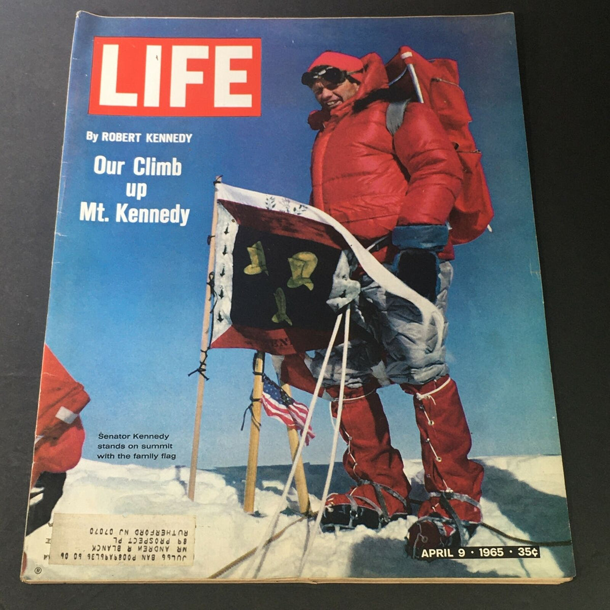 Cover of Life Magazine April 9, 1965 featuring the article 'Our Climb Up Mt. Kennedy' by Robert Kennedy, showcasing a climber in winter gear at the summit with flags and snow.
