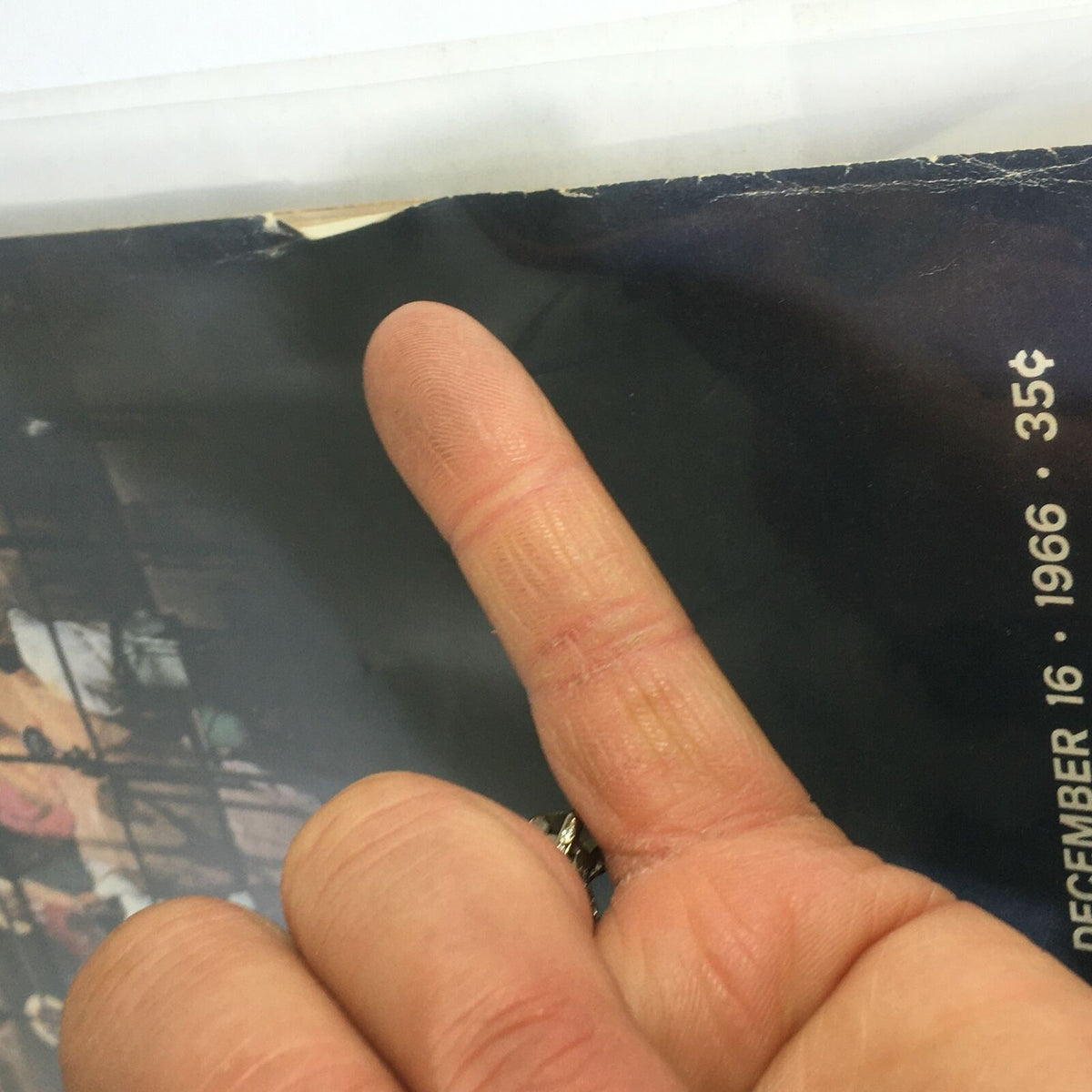 Close-up of the corner of the vintage Life Magazine cover dated December 16, 1966, showing a finger pointing at the publication's edge, highlighting the magazine's used condition.