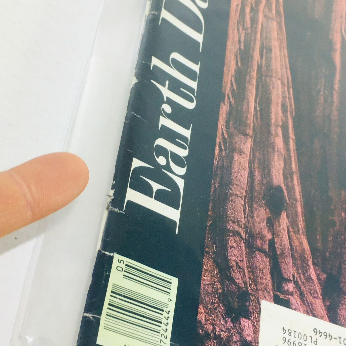 Close-up view of the edge of the VTG Life Magazine: May 1990 - Earth Day Year 1990, showing minor wear and a finger pointing at the damaged area, with visible barcode.