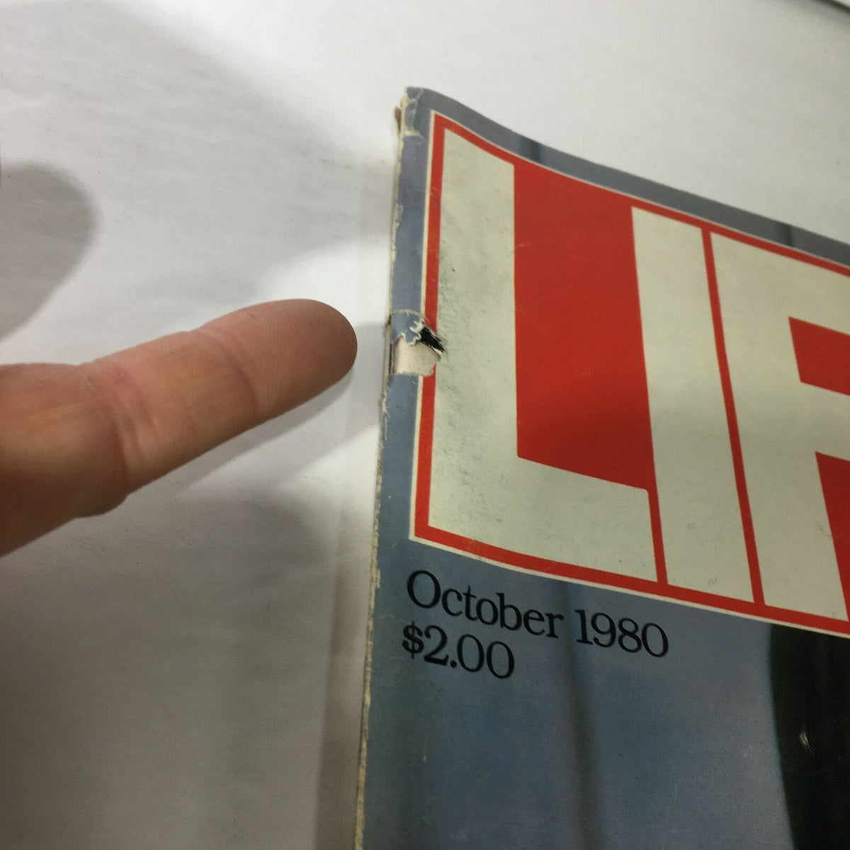 Close-up of the cover of the VTG Life Magazine from October 1980, showing wear and tear, including a damaged corner and the price of $2.00, highlighting its vintage condition.