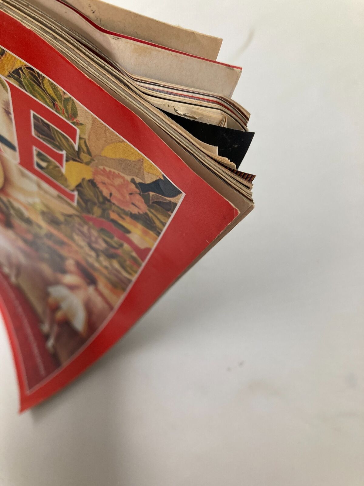 Close-up view of the edge of the VTG Time Magazine from October 26, 1987, featuring a day in the life of the Soviet Union, showcasing its worn pages and vibrant cover designs.