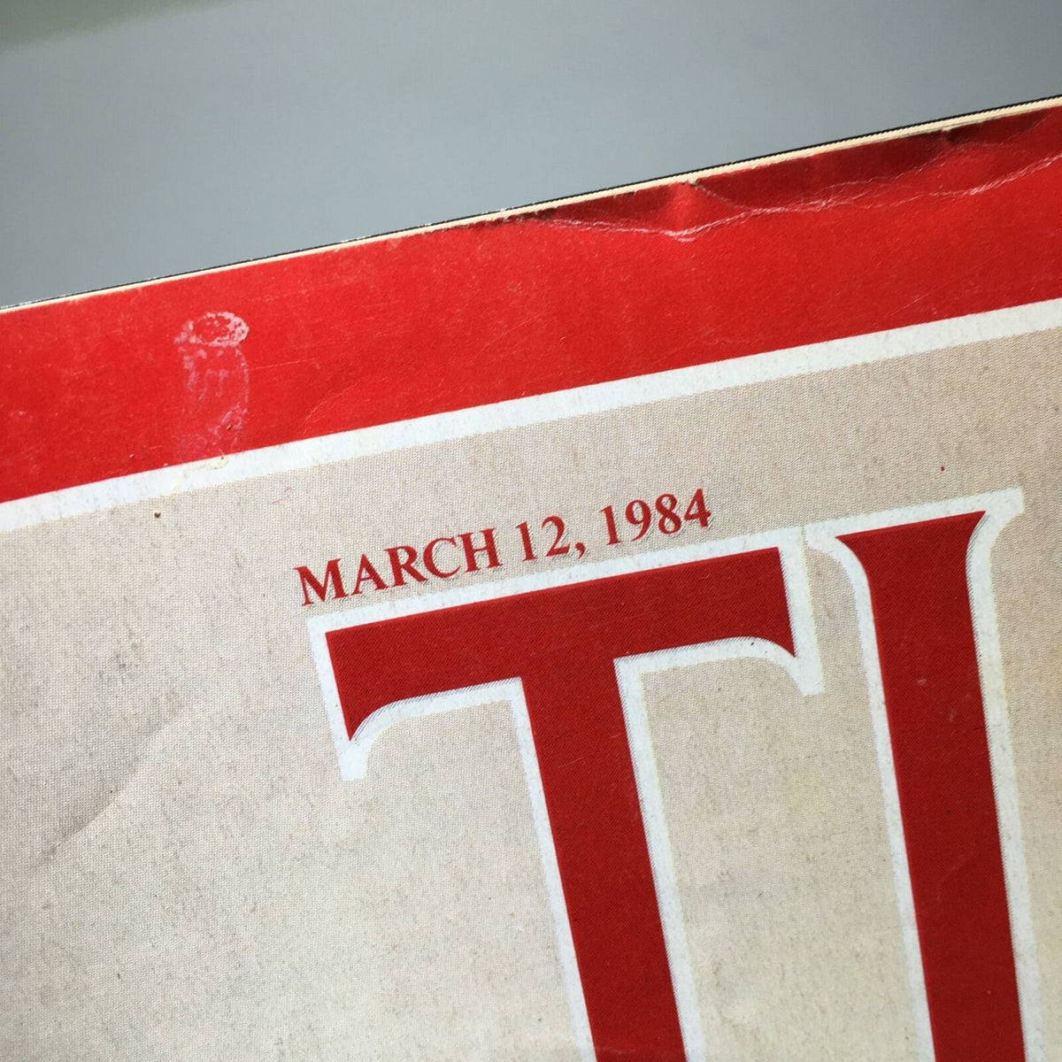 Close-up view of the date on the cover of Time Magazine, indicating March 12, 1984, as part of the issue titled 'Now It's A Race'.