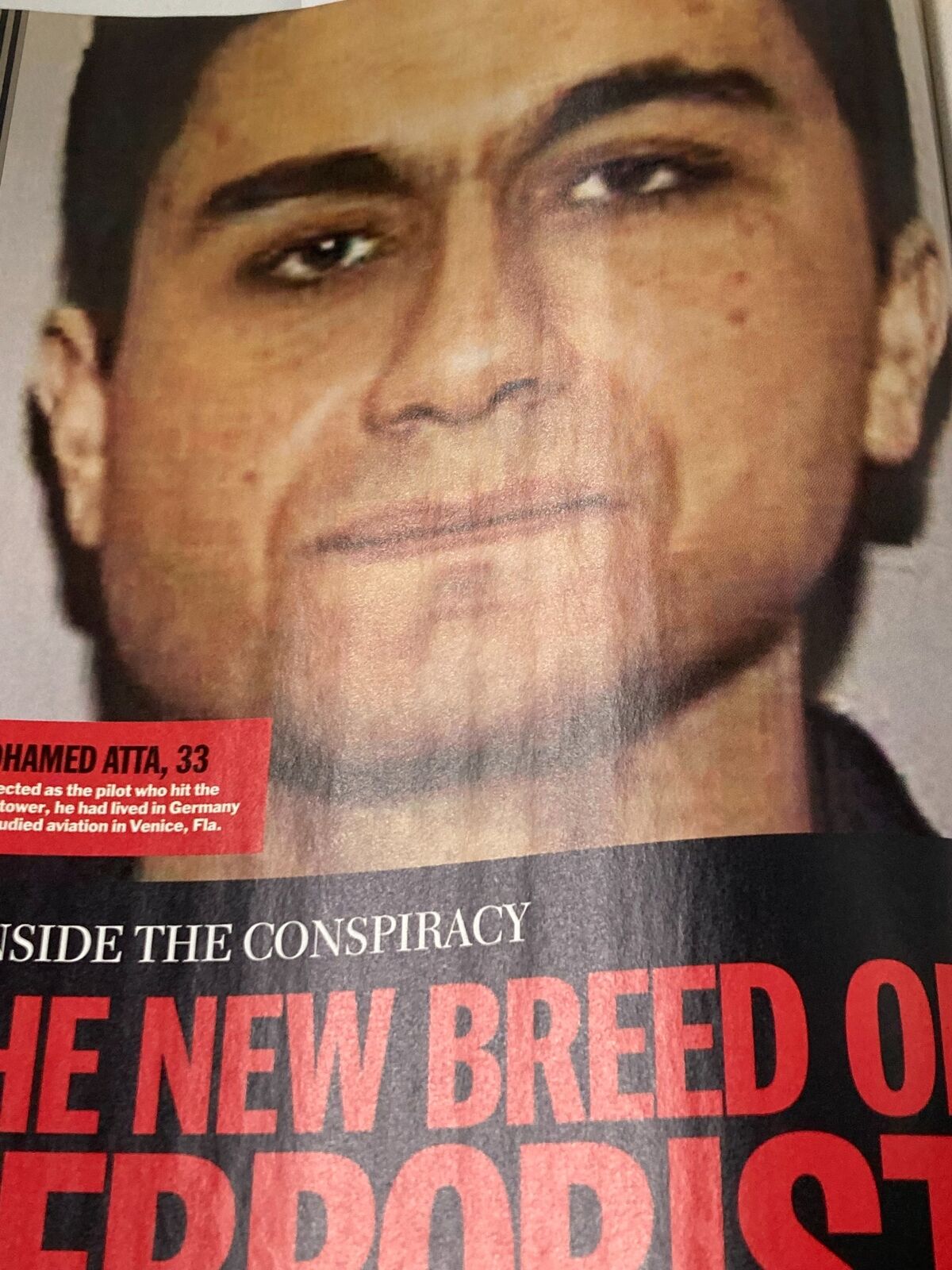 Close-up of Mohamed Atta, one of the hijackers from the September 11 attacks, with a headline stating 'The New Breed of Terrorist', featured in Time Magazine's September 24, 2001 issue titled "Out of the Ashes".