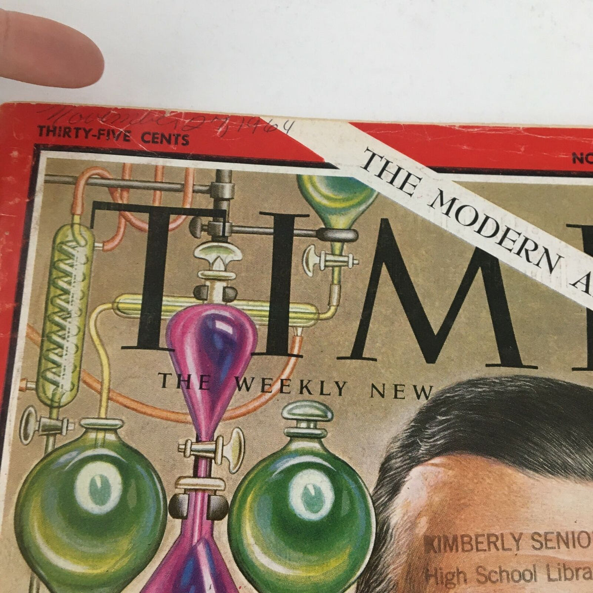 Close-up of the Time Magazine cover from November 27, 1964, highlighting the title 'The Modern Alchemists' with details of the scientific design and historical context.