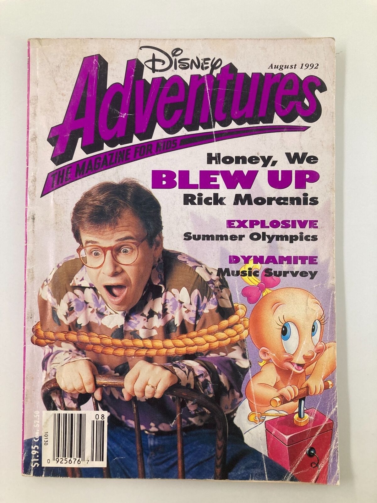 Disney Adventures Magazine August 1992 cover featuring Rick Moranis, promoting the Summer Olympics and showcasing a colorful design with cartoon characters, capturing the nostalgic essence of children's entertainment.