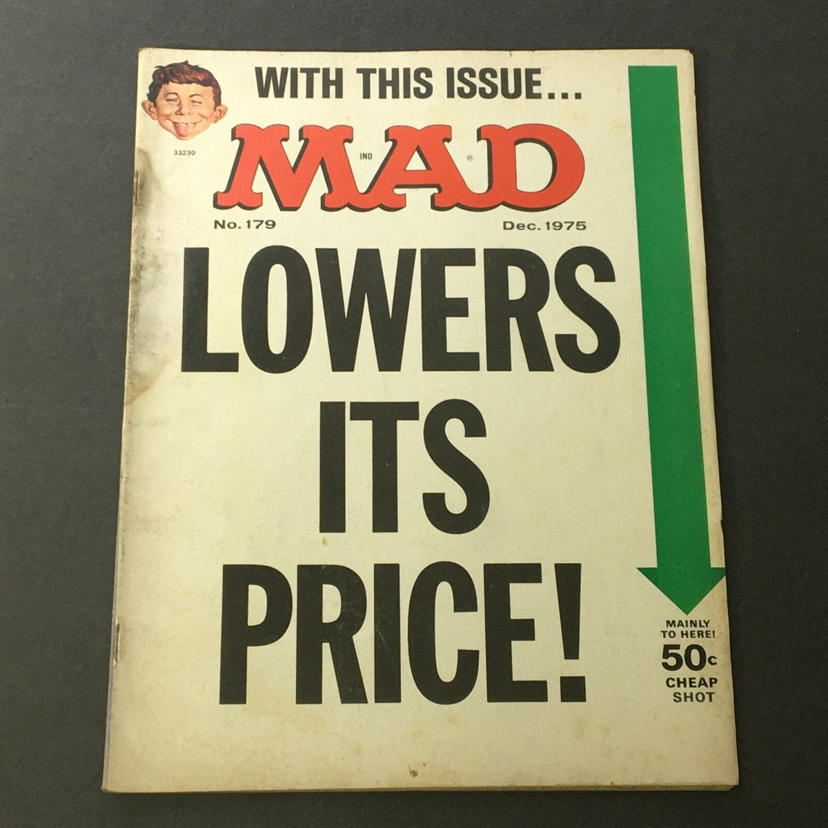 Cover of Mad #179 December 1975 featuring the text 'Lowers Its Price!' with an arrow pointing downwards, featuring Alfred Neuman, Snoopy, and Peanuts characters.