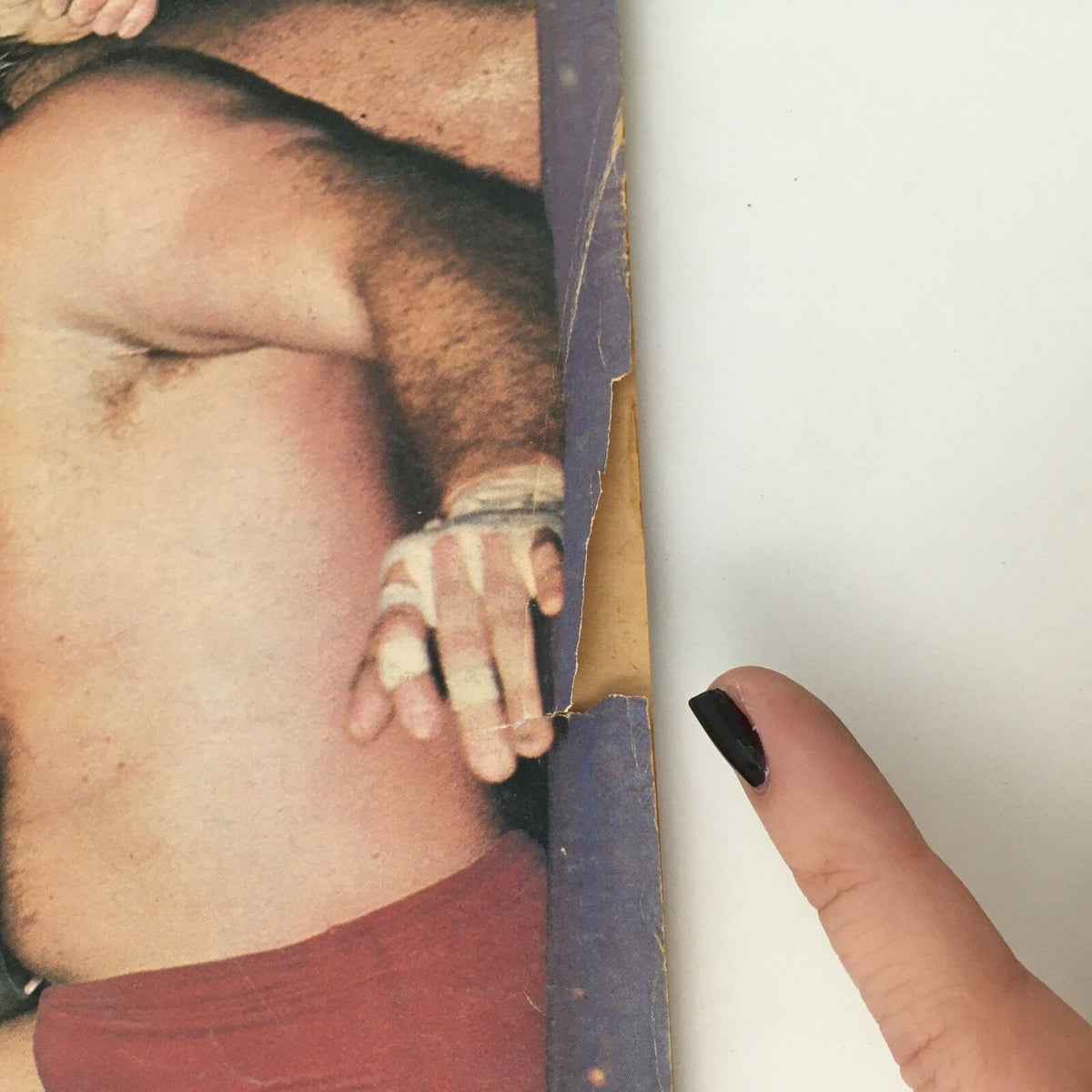 Close-up of the edge of the Sports Review Wrestling Magazine May 1980, highlighting wear and tear on the cover, consistent with vintage magazine age.