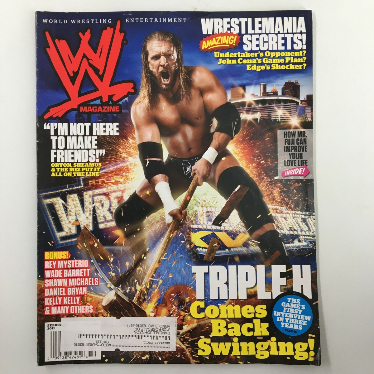 WWE Magazine February 2011 cover featuring Triple H returning to the ring, with vibrant colors and explosive imagery. Highlights include his comeback and Rey Mysterio inside.