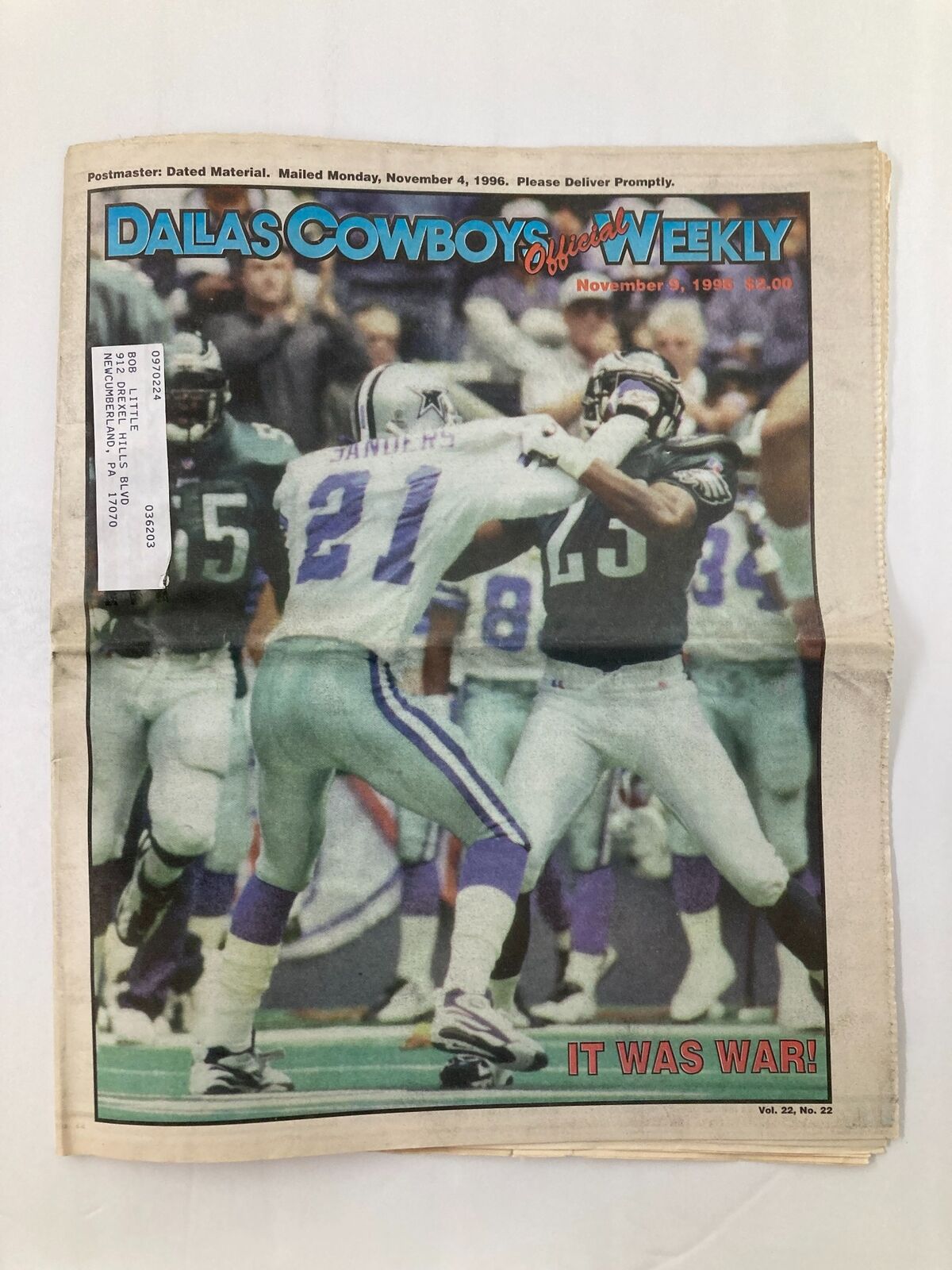 Dallas Cowboys Weekly Newspaper, November 9, 1996, Vol 22 #22 featuring an action shot of a football game, depicting a player in a blue jersey being tackled. The headline reads 'IT WAS WAR!' highlighting the competitive nature of the match.