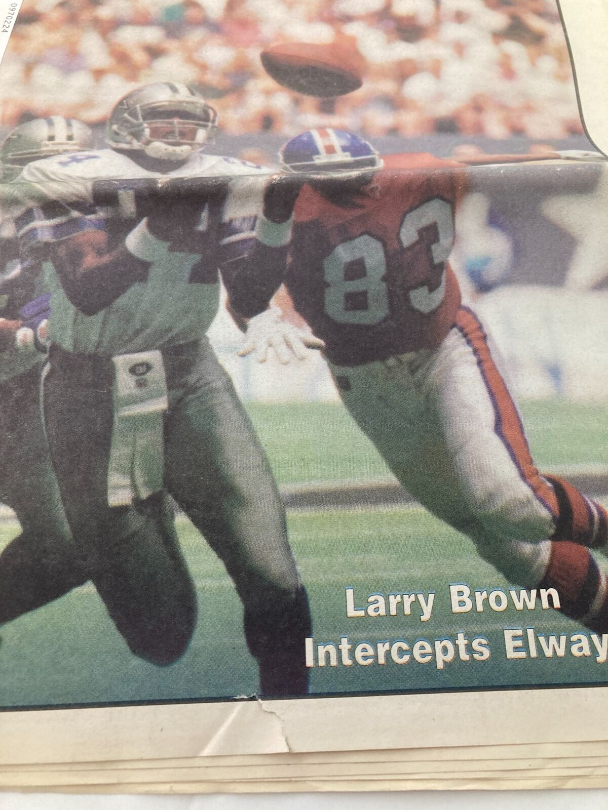 Close-up of the Dallas Cowboys Weekly Newspaper from September 16, 1995, highlighting Larry Brown intercepting Elway's throw. Includes details of the action during a football game.