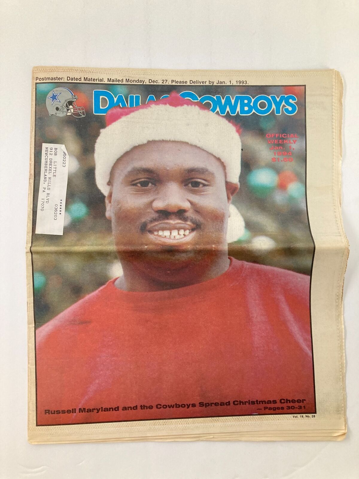 Dallas Cowboys Weekly Newspaper January 1 1994 Vol 19 #28 featuring Russell Maryland on the cover, showcasing him with a festive Santa hat and smiling. The newspaper is in good condition with a label on the front and minor wear, folded and protected by plastic.