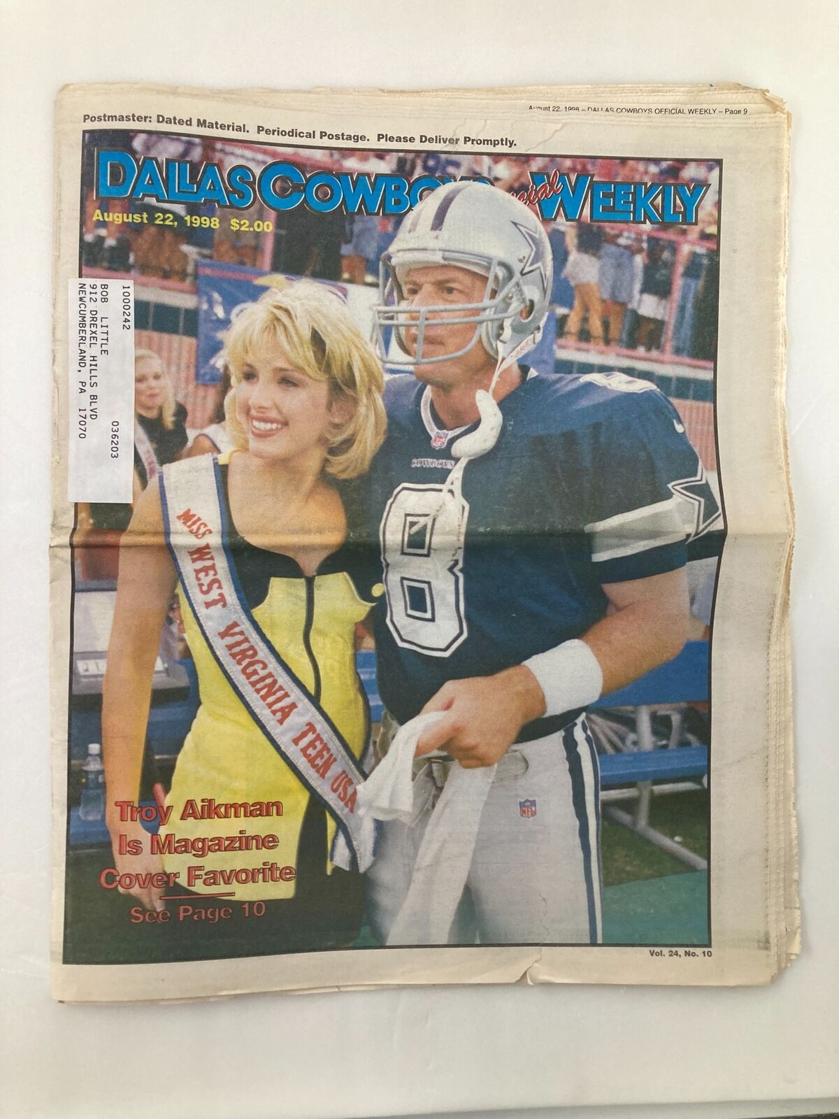 Front cover of the 'Dallas Cowboys Weekly' newspaper from August 22, 1998, featuring Troy Aikman and a woman in a beauty pageant sash. Vol 24 #10.