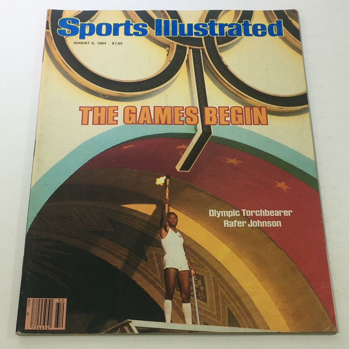 Cover of Sports Illustrated magazine dated August 6, 1984, featuring Olympic Torchbearer Rafer Johnson with the caption 'THE GAMES BEGIN'.