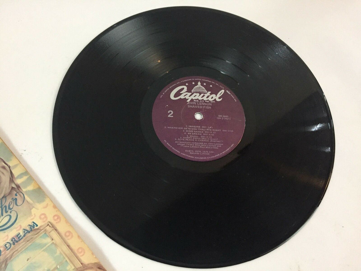 Close-up of the vinyl record titled 'JOHN LENNON--SHAVED FISH--APPLE--SW-3421', showcasing the label and detail of the record surface.
