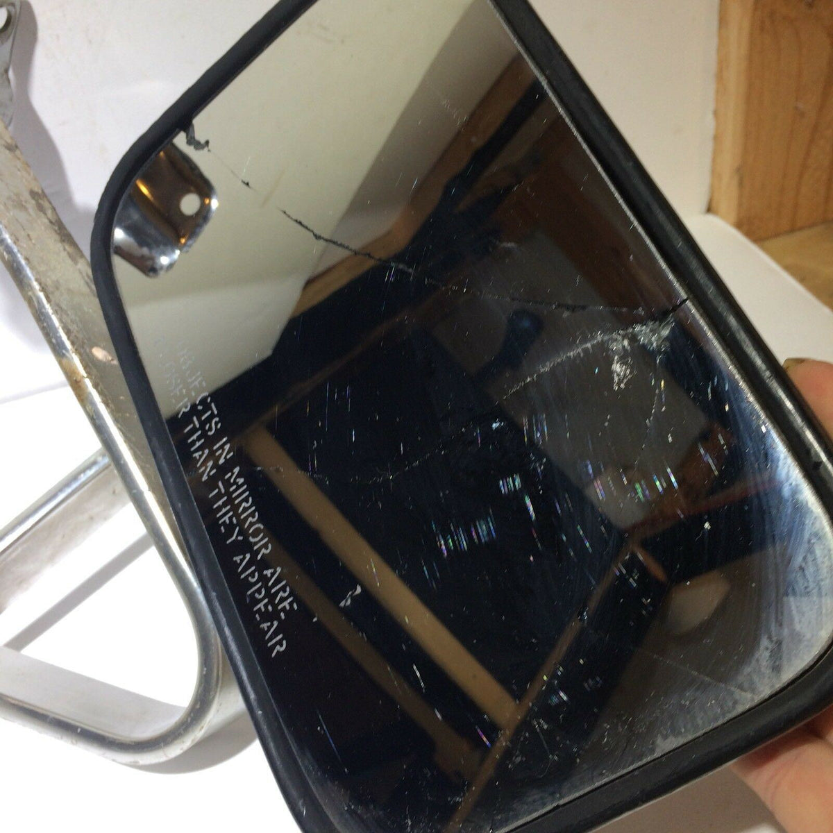 Detailed view of a worn mirror from the Pickup Truck Set of Side Manual Mirrors with Chrome & Metal Housing, showing scratches and cracks on the surface.