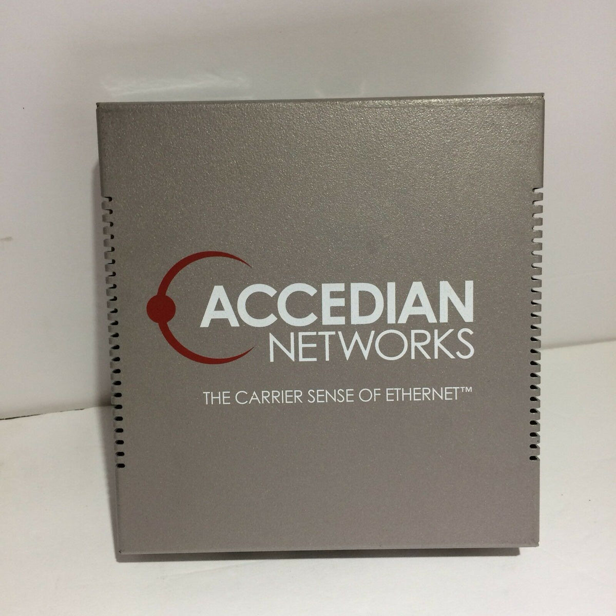 ACCEDIAN NETWORKS AEN-100-OE-Ethernid device with the logo of Accedian Networks displayed prominently on a gray background, designed for Ethernet connectivity and monitoring.