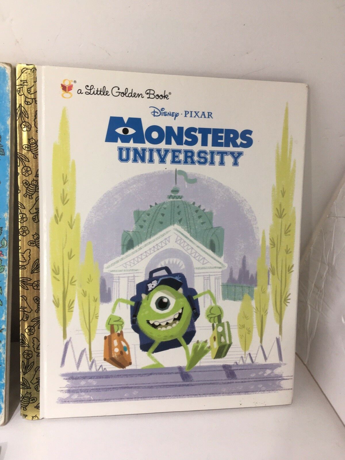 Little Golden Book Disney Monsters University showing the character Mike Wazowski, ready for college with his accessories, part of a nostalgic Disney collection.