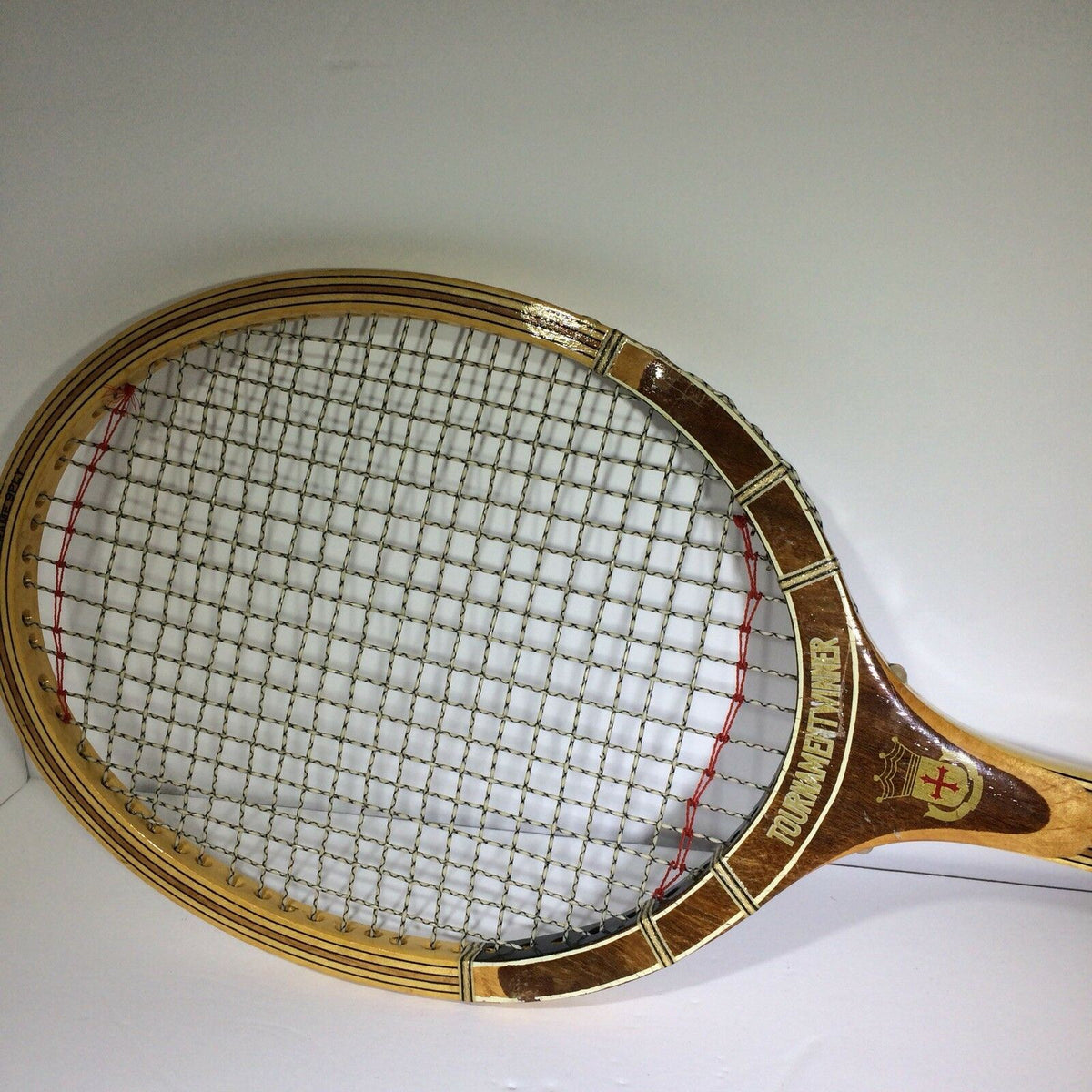 Detailed shot of the head of the Vintage Tournament Wood Tennis Racket Ash Frame 9 Ply Andia, emphasizing the stringing and branding.