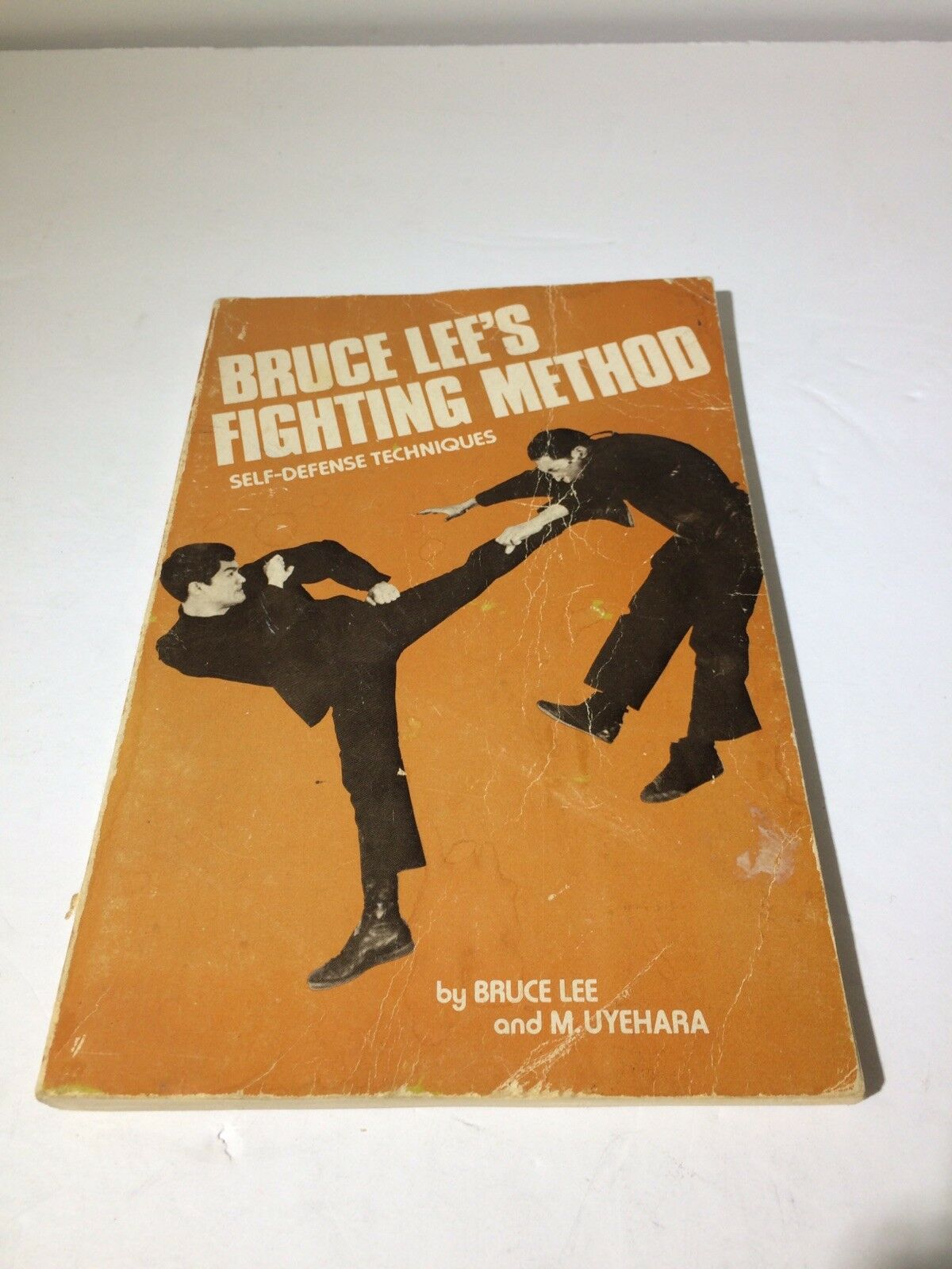 Cover of '1976 Bruce Lee’s Fighting Method Self-Defense Techniques' featuring illustrations of self-defense techniques.