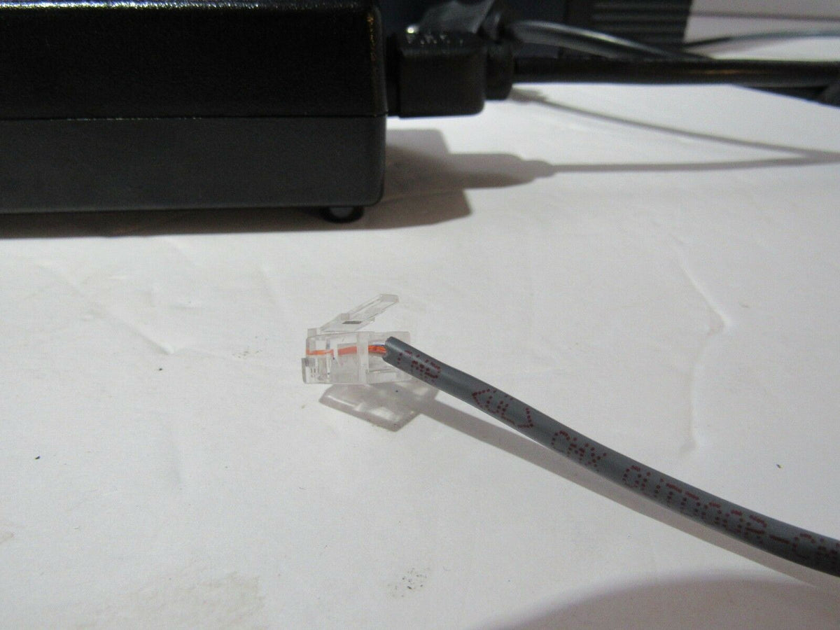 Close-up of a connector and cable, showing part of the Panasonic KX-TDA50 Hybrid IP-PBX Voicemail Processing System working with power cord.