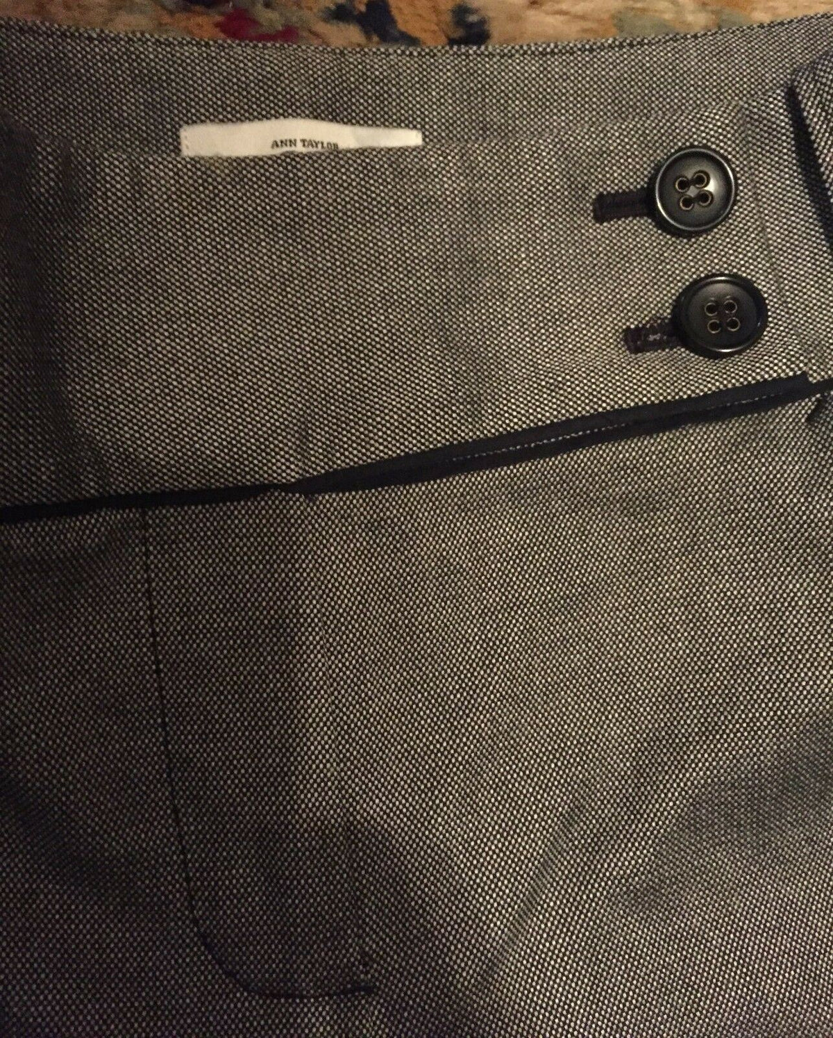 Close-up of double button closure on Ann Taylor Loft dress pants, emphasizing the sophisticated style of the fine white and black design.