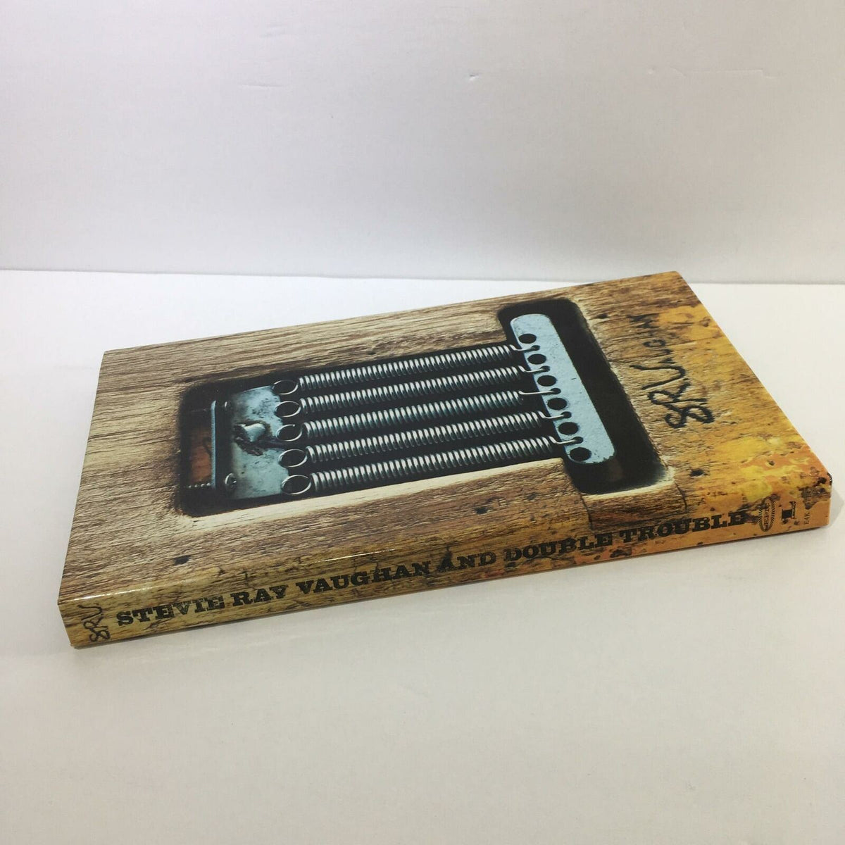 Cover of Stevie Ray Vaughan And Double Trouble 4 Disc Box Set Audio CD, featuring a vintage design with prominent guitar details.