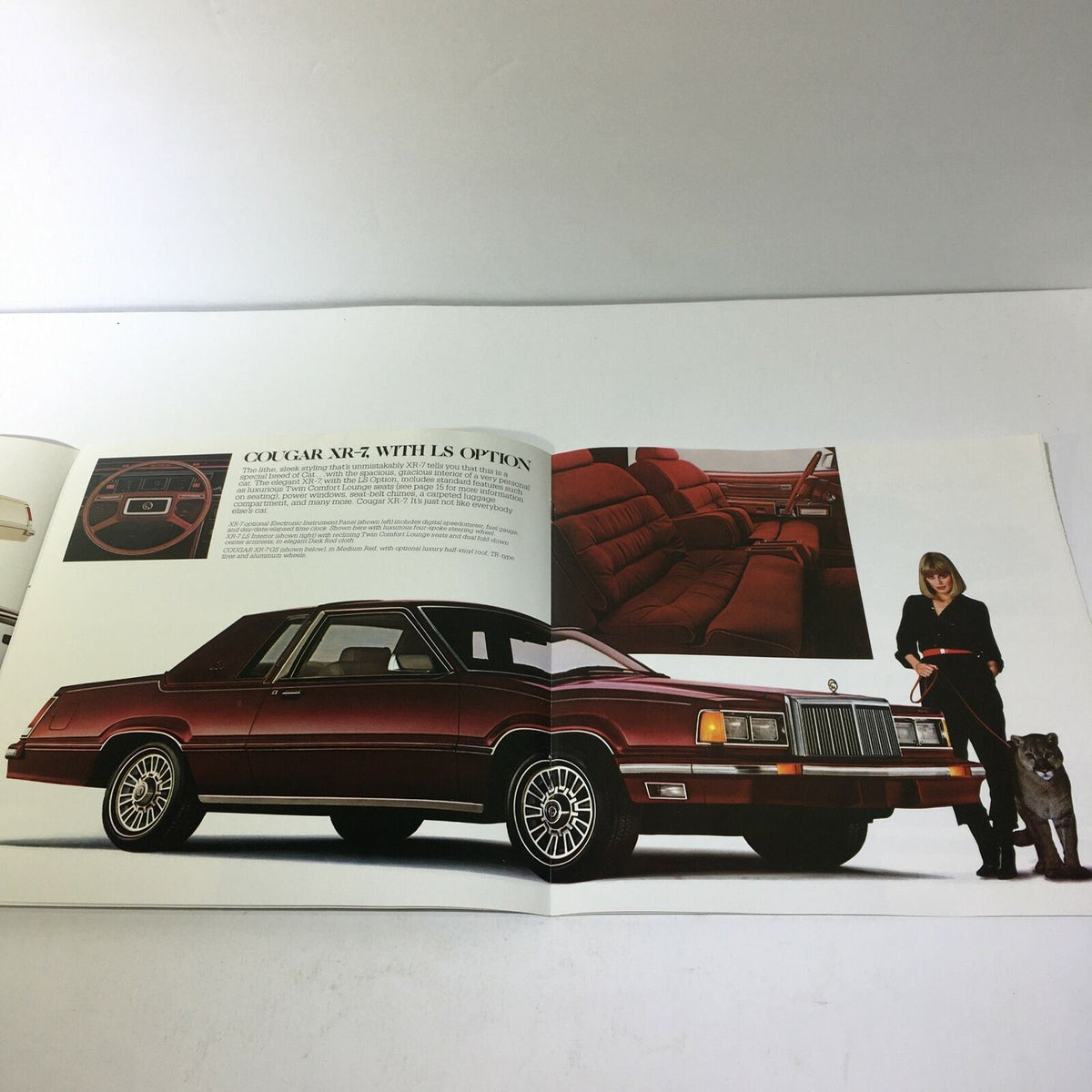 Exterior view of the 1981 Lincoln-Mercury Cougars XR-7 Inspired Sedan in deep red, showcased with a woman, as seen in the car sale brochure.