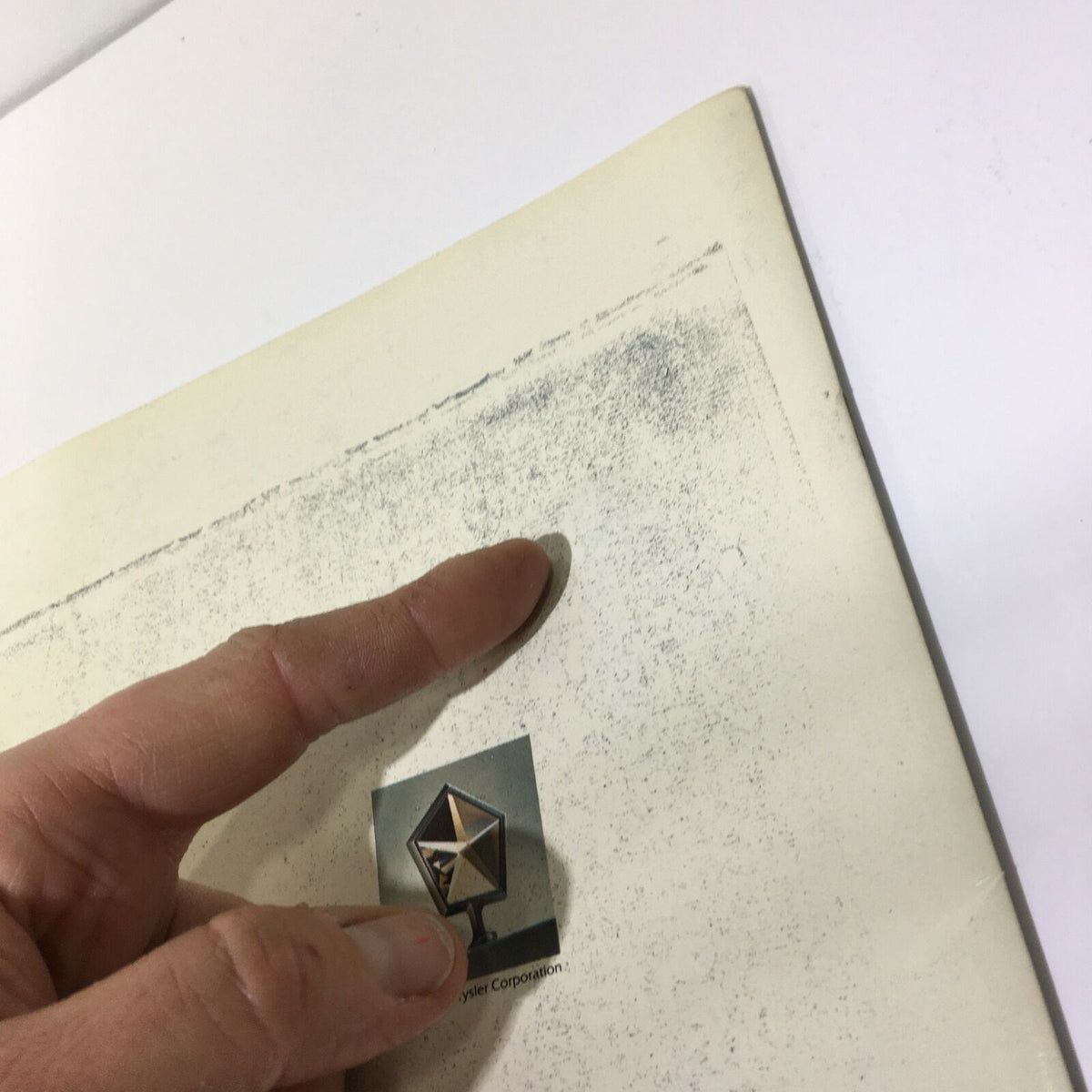 Close-up of 1981 Imperial in Sterling Silver Crystal Coat - Imperial Car Sale Brochure showing a finger pointing at the brochure's logo.