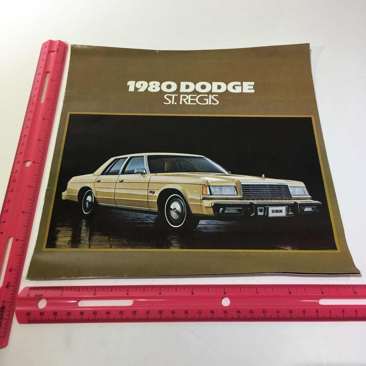 1980 Dodge St. Regis 225 Slant Six Standard V-8 Engine Options Car Brochure with an image of the car on the cover highlighted against a brown background.
