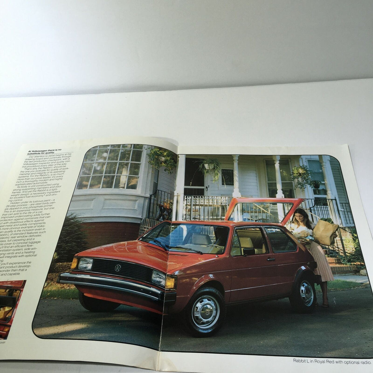 Interior spread of the 1983 Volkswagen Rabbit GTI 2-Door Sedan Car Sale Brochure showcasing a Royal Red Volkswagen Rabbit L parked outside a house.