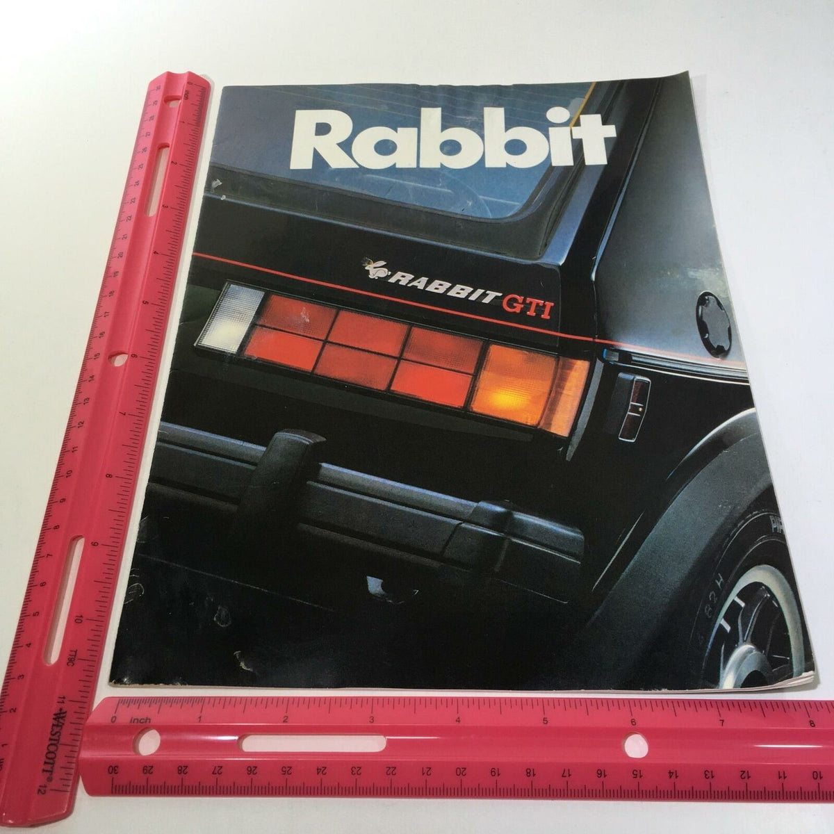 Another view of the 1983 Volkswagen Rabbit GTI 2-Door Sedan Car Sale Brochure showcasing the cover with the title 'Rabbit' and a detailed image of the vehicle's rear lights.