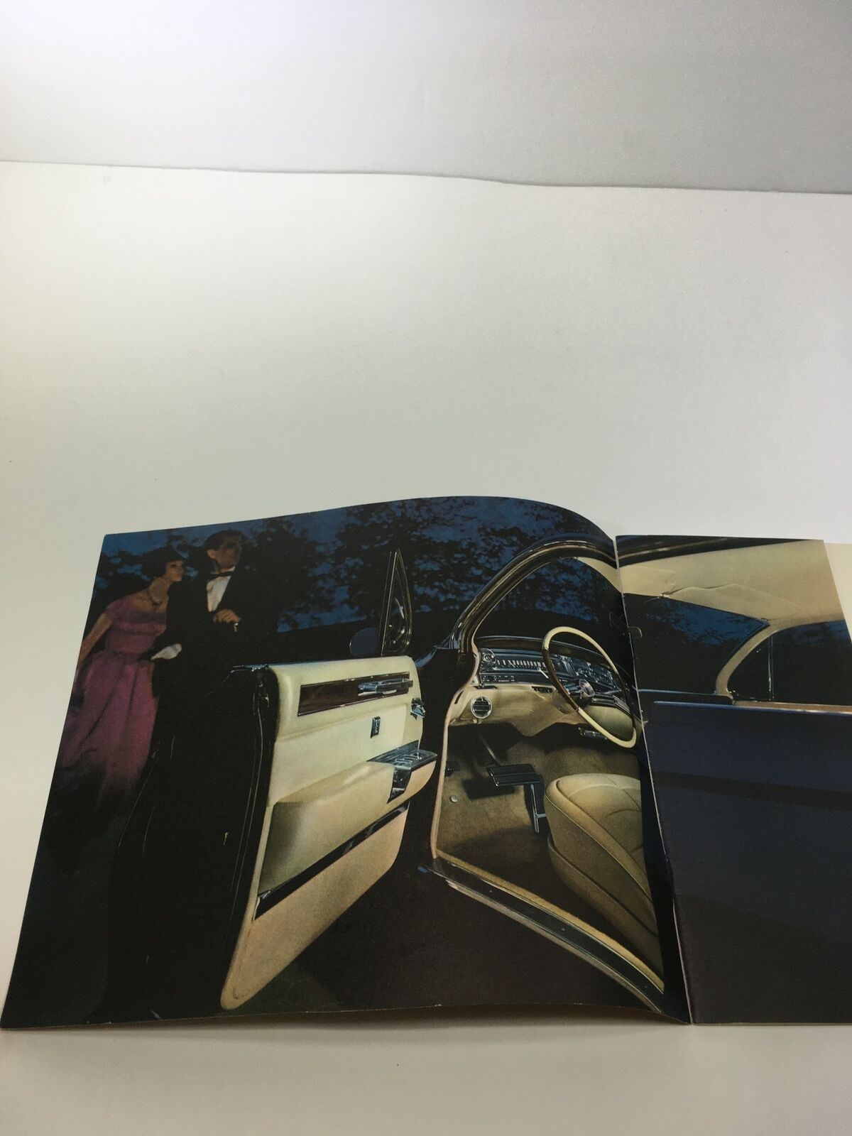 Interior view of the 1961 Cadillac The Sixty-Two Coupe, showcasing luxurious design with couples beside the car, perfect for enthusiasts.