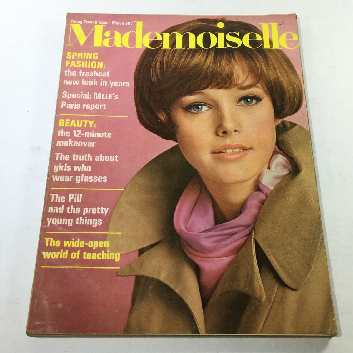 Cover of VTG Mademoiselle Magazine: March 1967 featuring a stunning woman with a stylish bob haircut and scarf, showcasing the fashion trends of the 1960s. The magazine highlights spring fashion, beauty tips, and a special Paris report.