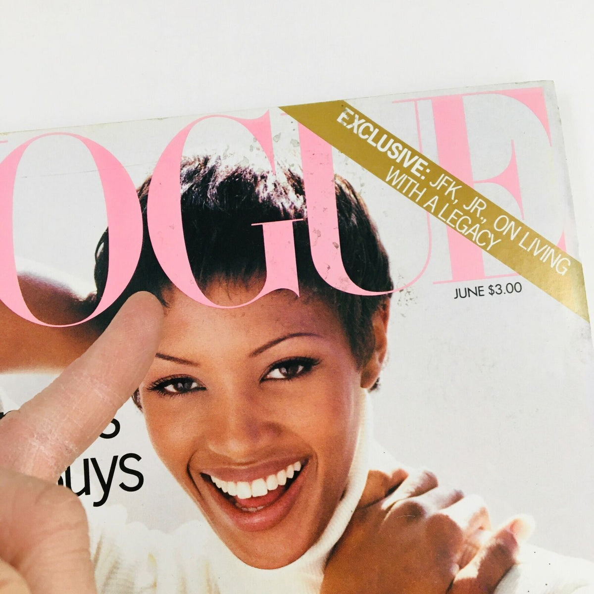 Cover of Vogue Magazine June 1993 featuring Naomi Campbell, showcasing her smile and chic fashion sense with a finger pointing at the iconic logo.