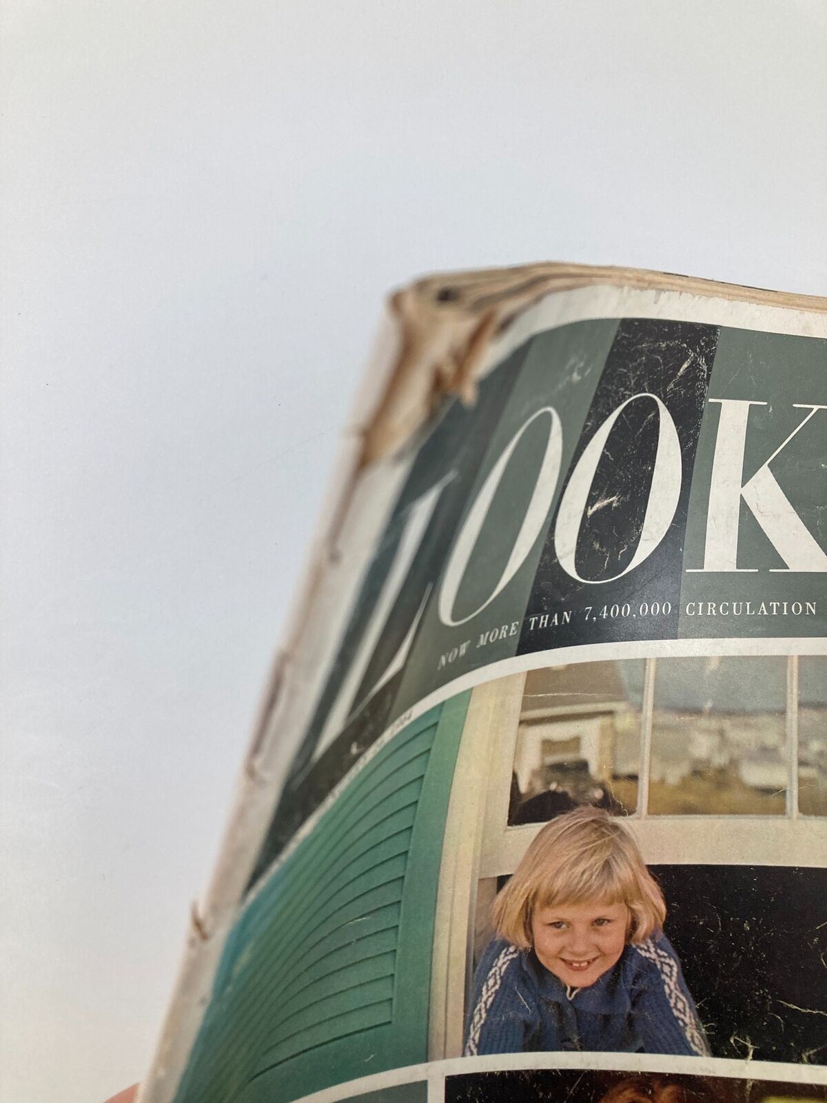Side view of the VTG Look Magazine January 14, 1964, showing the cover design featuring a smiling child and noticeable wear on the edges.