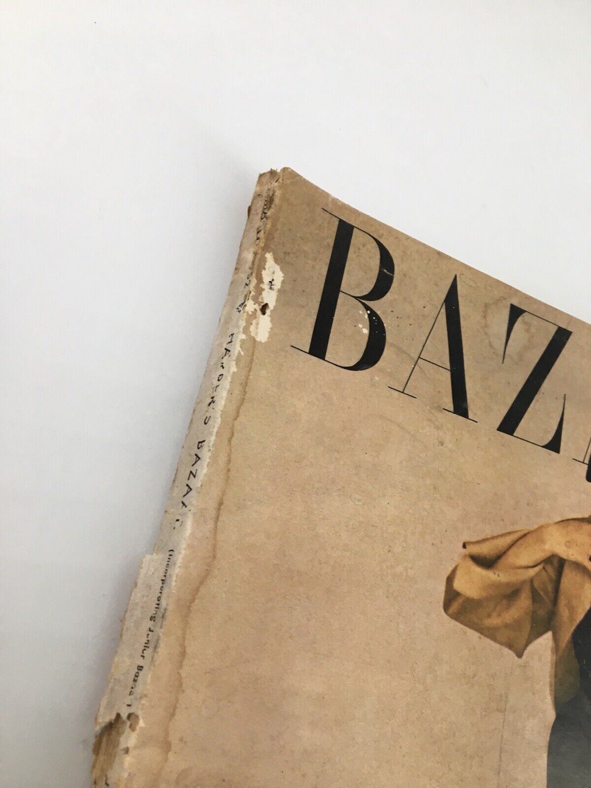 Close-up view of the spine of Harper's Bazaar March 1952 Fashion edition, showing wear and the magazine's title.