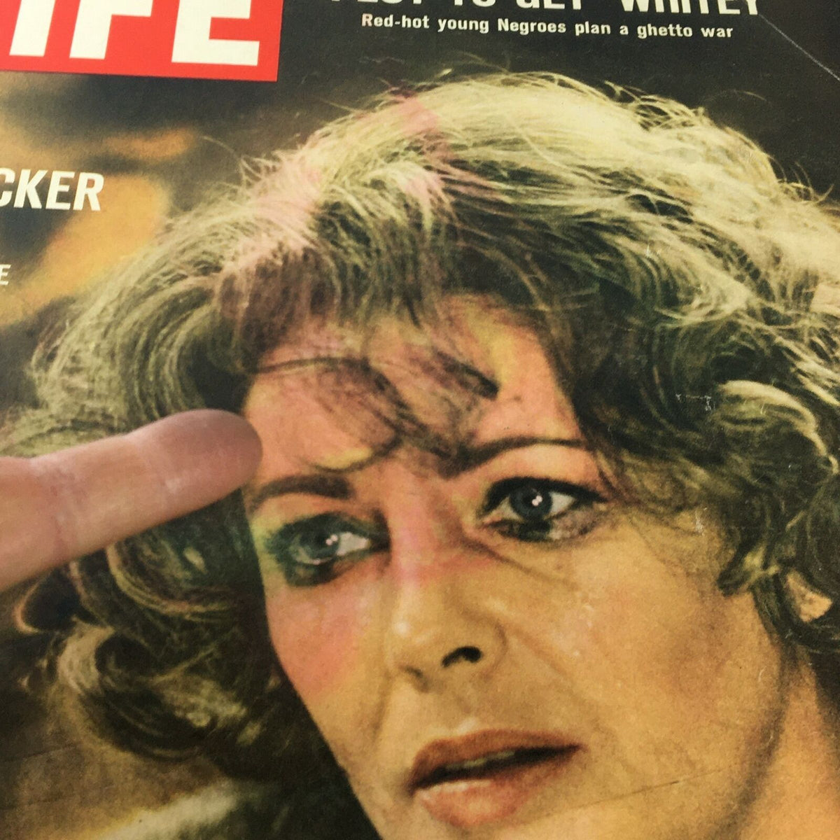Detailed view of the cover of VTG Life Magazine from June 10, 1966, showing Elizabeth Taylor's face and the text 'LIZ IN A SHOCKER'. A finger is pointing at her hair, emphasizing the artistry of the photograph.