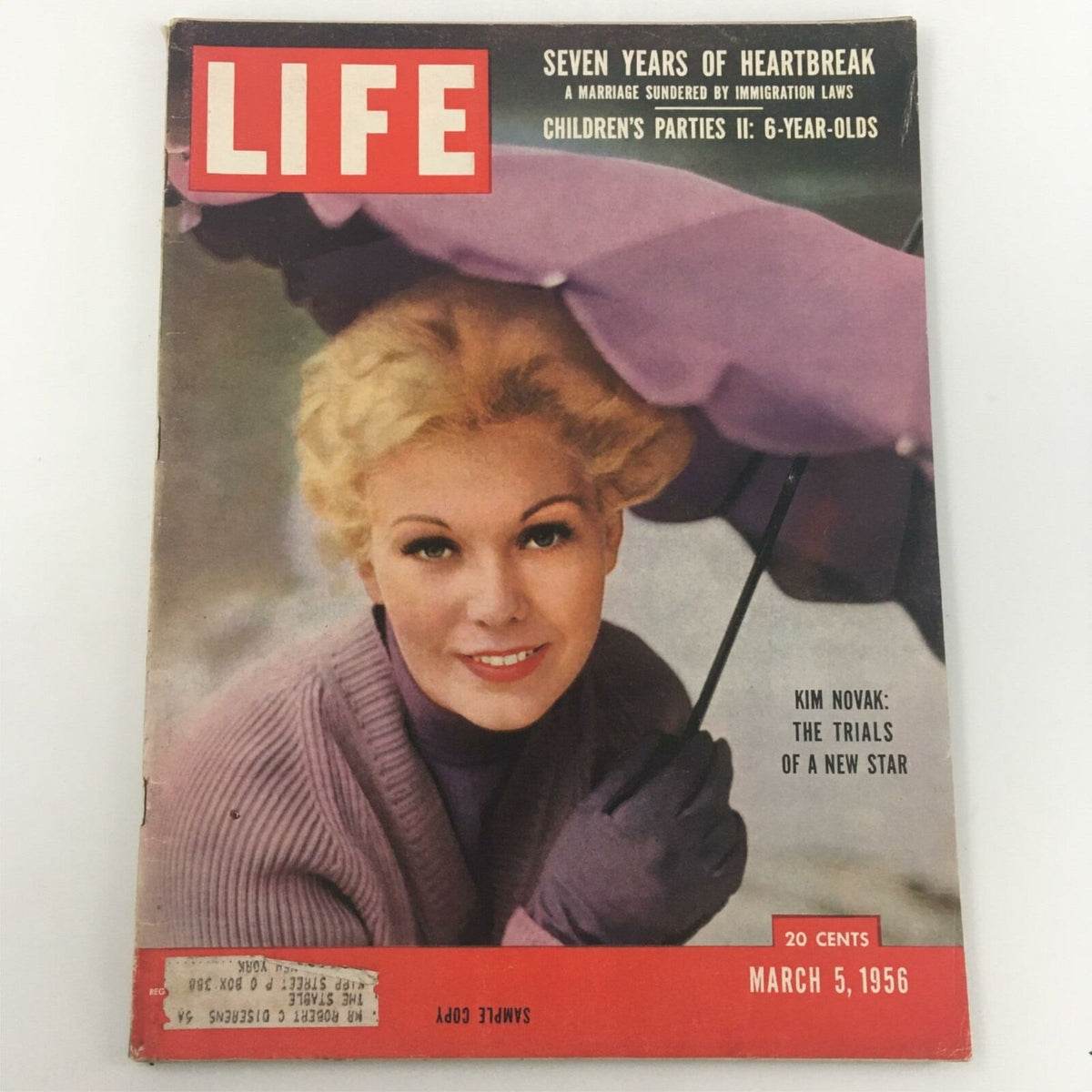 Vintage Life Magazine from March 5, 1956 featuring Kim Novak on the cover, showcasing her style with a purple umbrella and sweater, marked as a sample copy.