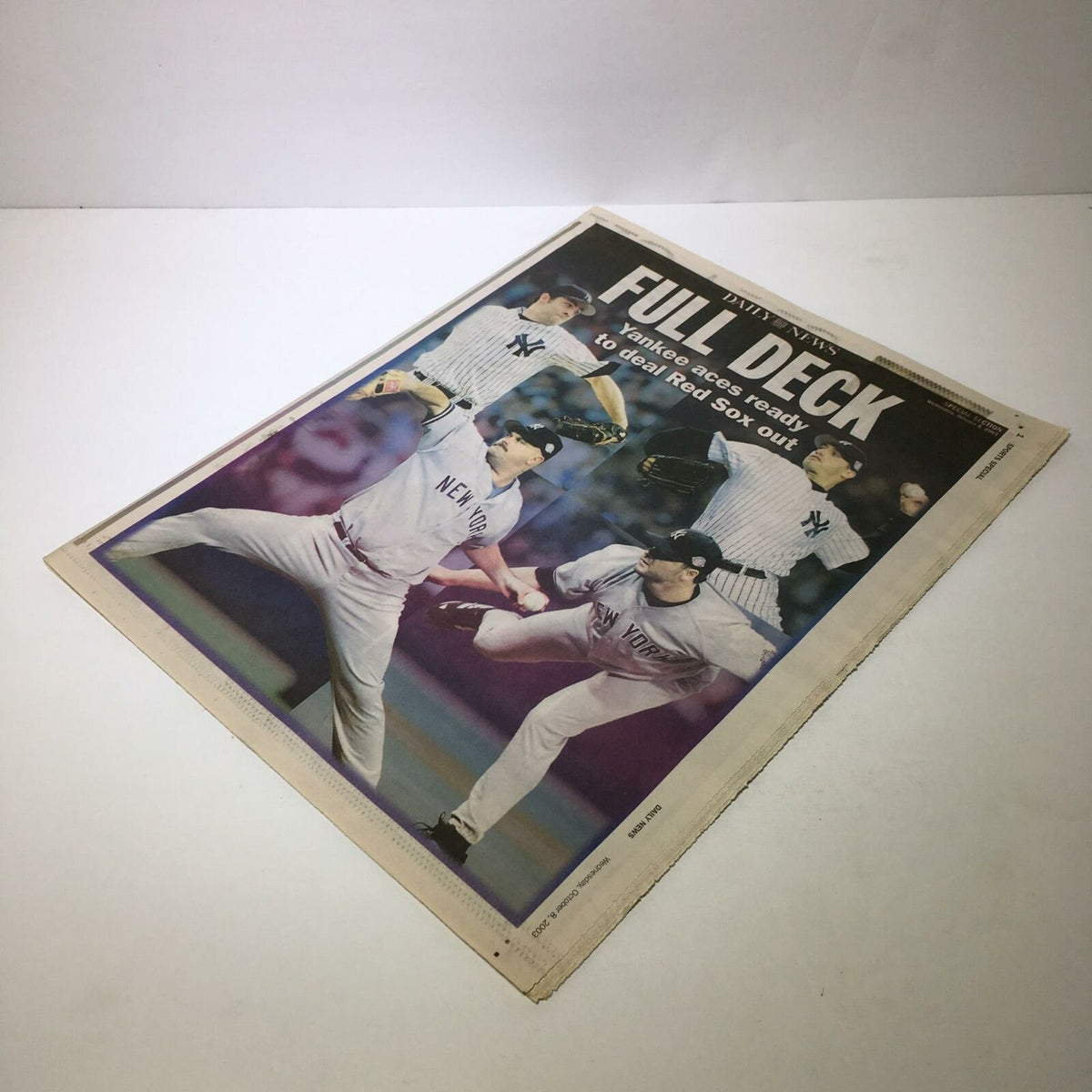 The front page of a sports newspaper featuring the New York Yankees players in action, with the headline 'Full Deck: Yankees Ready to Deal Red Sox Out'. Accompanied by the title 'Sports Special Daily News: Oct 8 2003 Yankee Aces Ready 2 Deal Red Sox Out'.