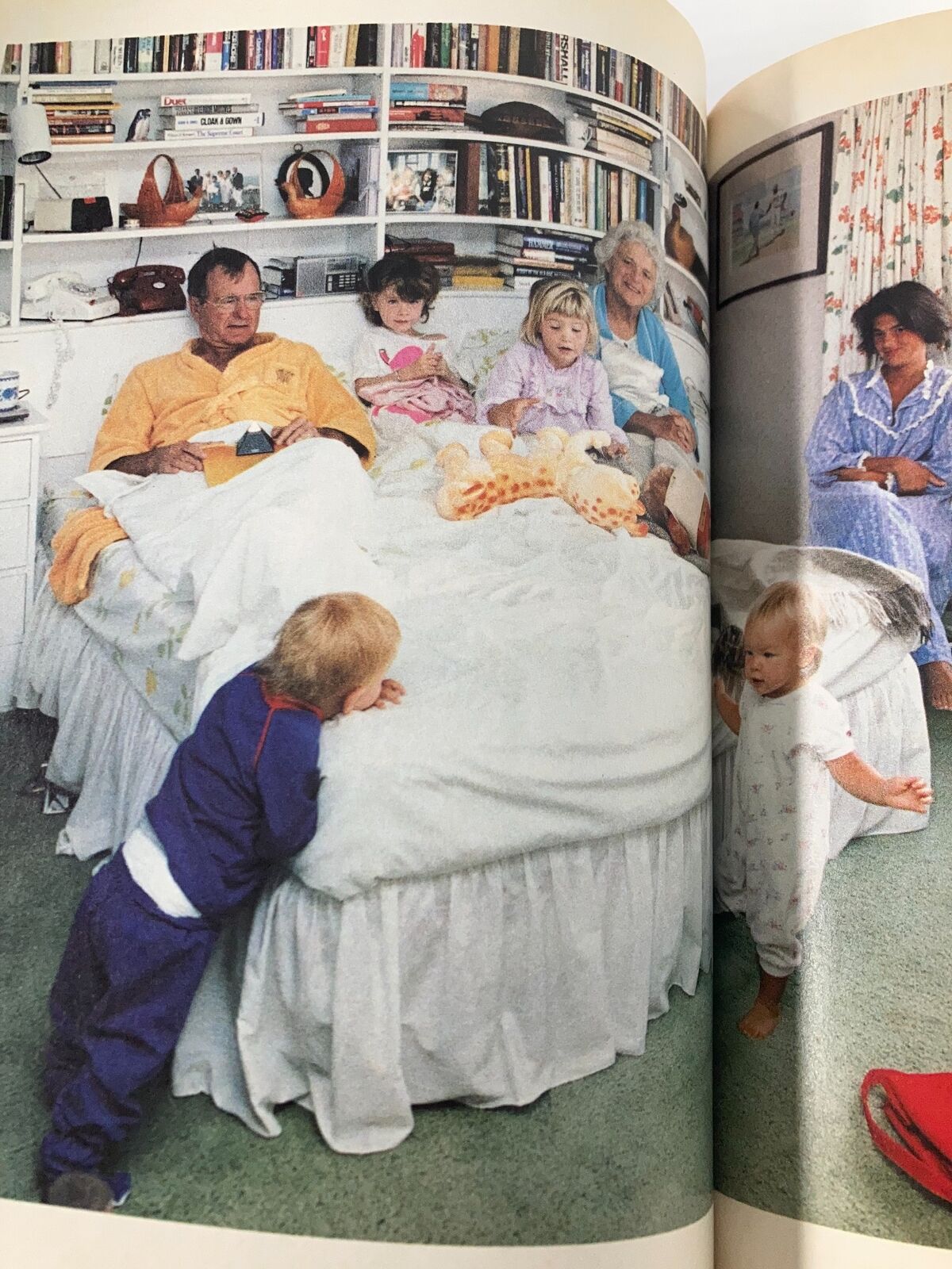 Life Magazine Fall 1990 Classic Moments by John Loengard capturing a family scene with multiple generations gathered in a cozy bedroom, sharing a moment of togetherness, highlighted by vibrant colors and playful children's attire.