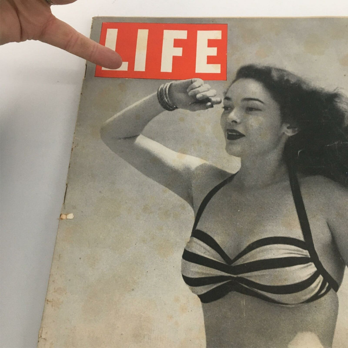 Close-up of the cover of VTG Life Magazine July 9 1945, highlighting a woman in a striped bathing suit, part of a historic issue focusing on the USS Bunker Hill and mid-20th century fashion.