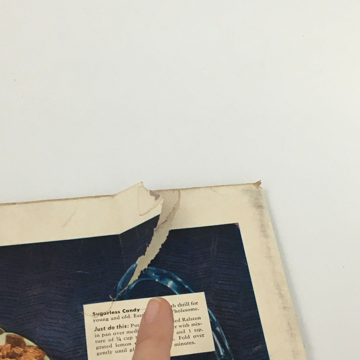 Close-up of a vintage Life Magazine from August 24, 1942, showing a torn edge and a feature on Shredded Ralston cereal, highlighting a recipe and a woman pointing at it.