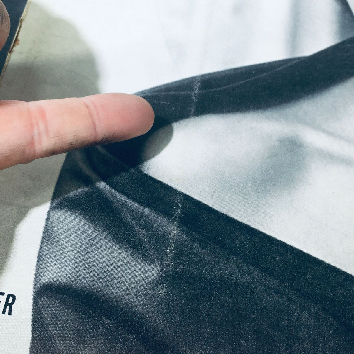 Close-up image of the VTG Life Magazine cover showing details of the fabric and a hand pointing to imperfections, highlighting its vintage condition.