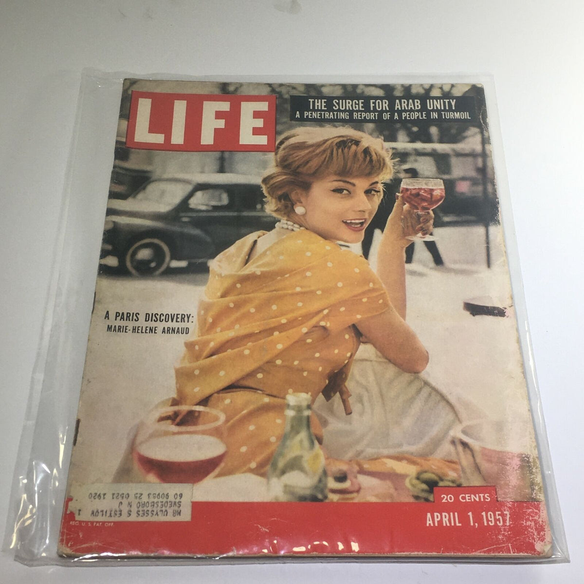 Cover of VTG Life Magazine dated April 1 1957, featuring the headline 'The Surge For Arab Unity' and a captivating image of a woman in a polka dot dress holding a drink, along with the profile of Marie-Helene Arnaud.