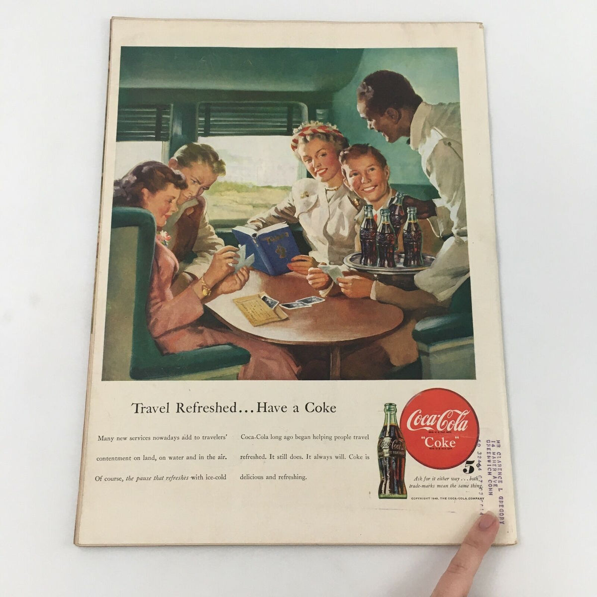 Inside page of a vintage advertisement for Coca-Cola, depicting a group of friends traveling by train and enjoying refreshments, showcasing mid-century leisure culture.