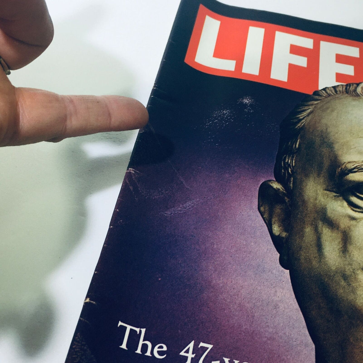 Close-up of the cover of the April 9, 1971 issue of Life Magazine showing signs of wear, including creases and a finger pointing at the variations, highlighting the vintage nature of 'Reign of J. Edgar Hoover: FBI Emperor'.
