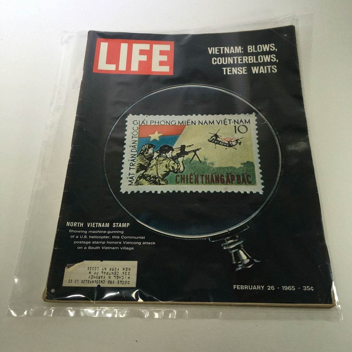 Cover of Life Magazine dated February 26, 1965, featuring the title 'Vietnam: Blows, Counter-blows, Tense Wait' and an image of a North Vietnam stamp depicting a helicopter and soldiers. The magazine is preserved in plastic, suitable for collectors.