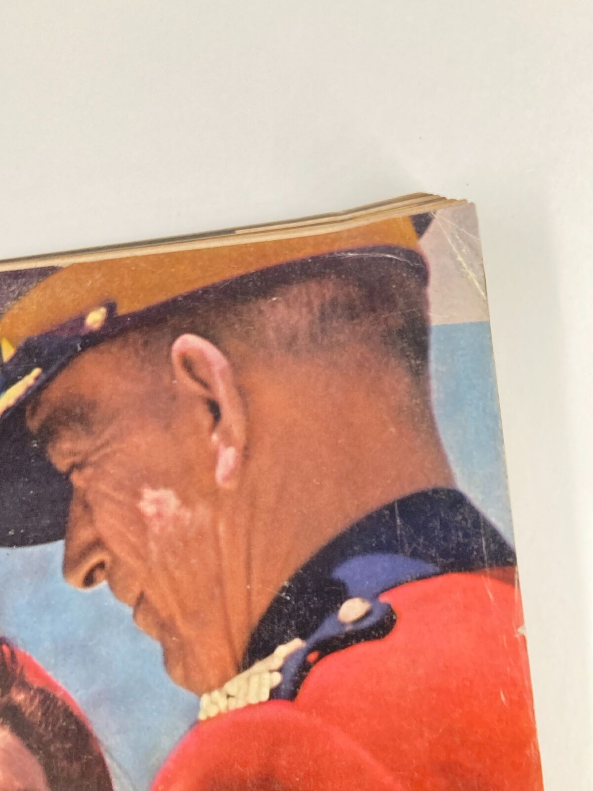 Close-up of a male figure in a red uniform with a yellow and black hat, featured in the vintage Life Magazine dated May 26, 1961, showcasing Jacqueline Kennedy and the Kennedys in Canada.